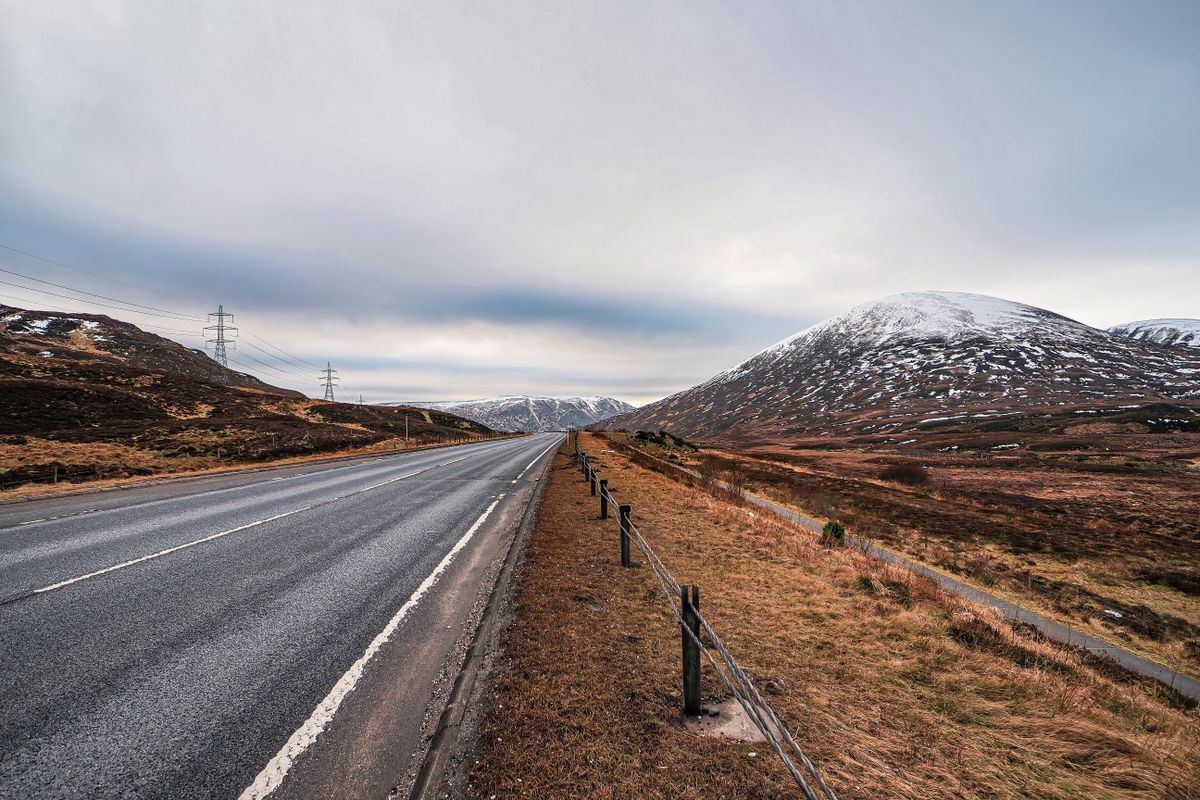 A snow-covered mountain road in the Scottish Highlands during winter