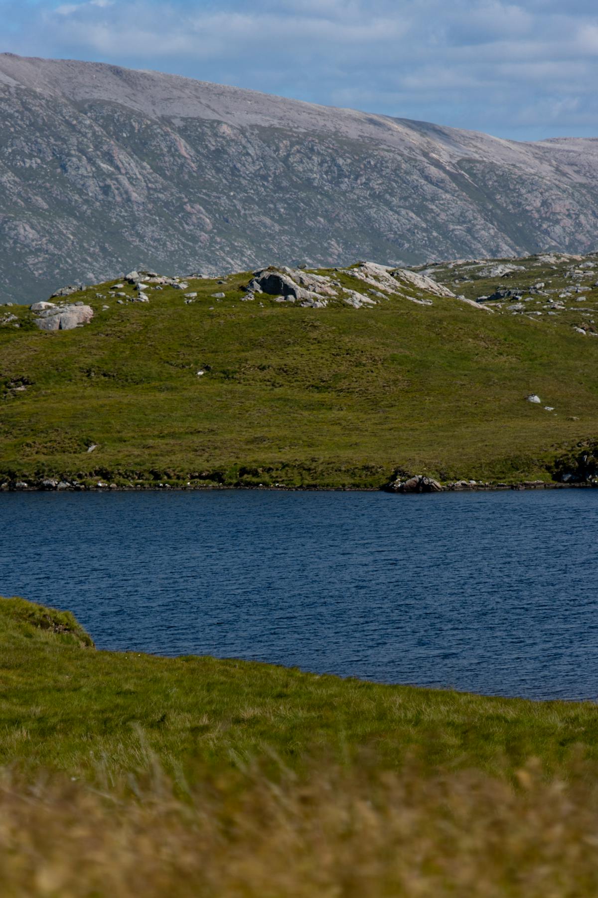 A tent pitched beside a Scottish loch with mountains in the background